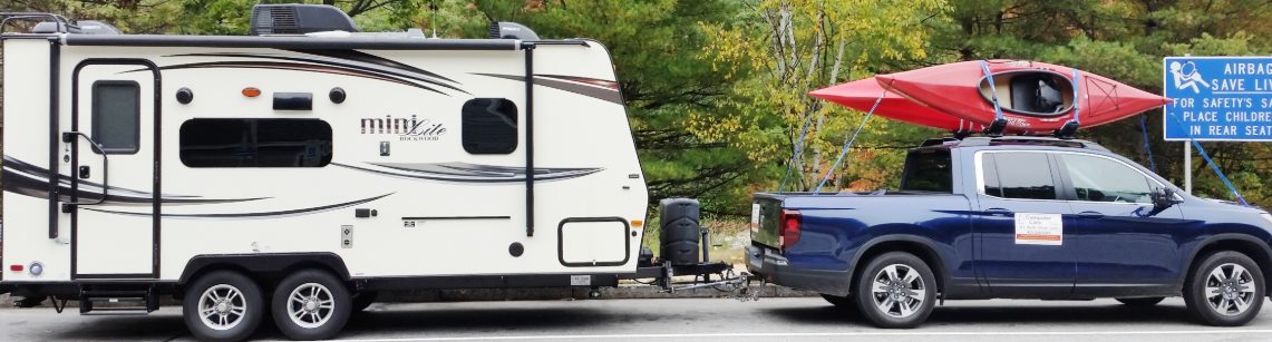 A row of travel trailers and fifth-wheels in an RV park